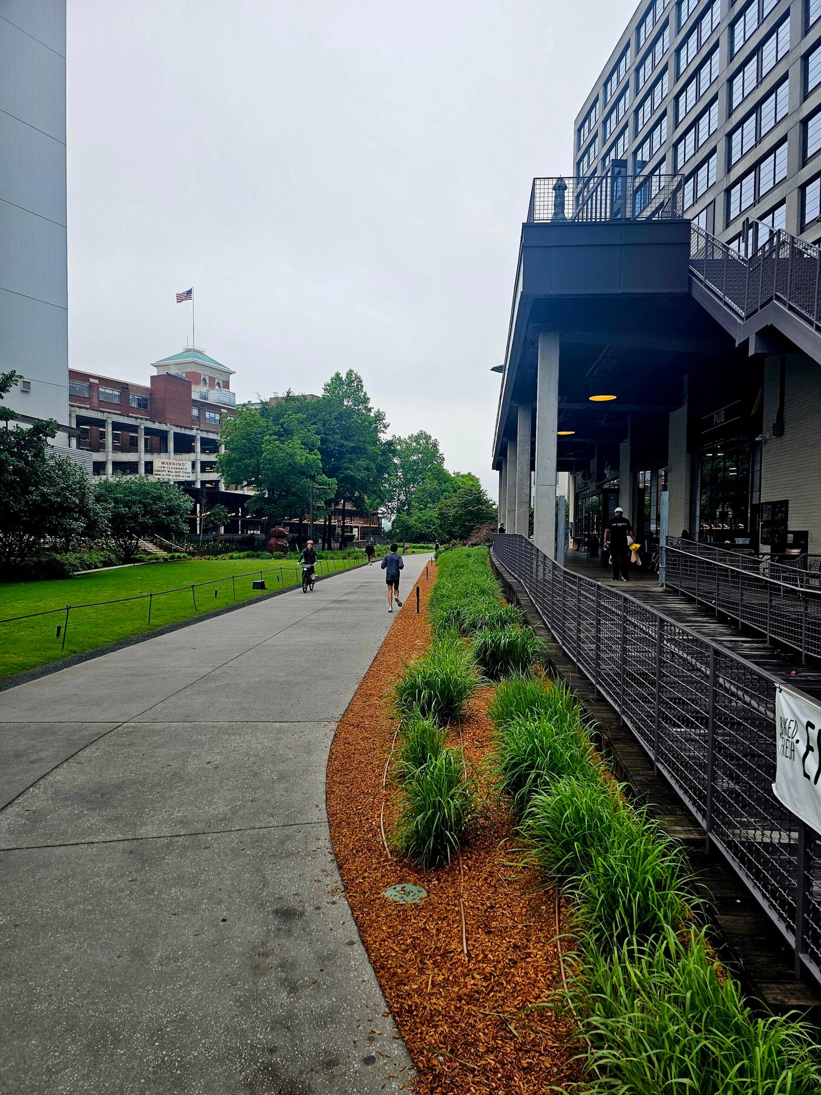 A cyclist and pedestrians on the BeltLine beside Ponce City Market.