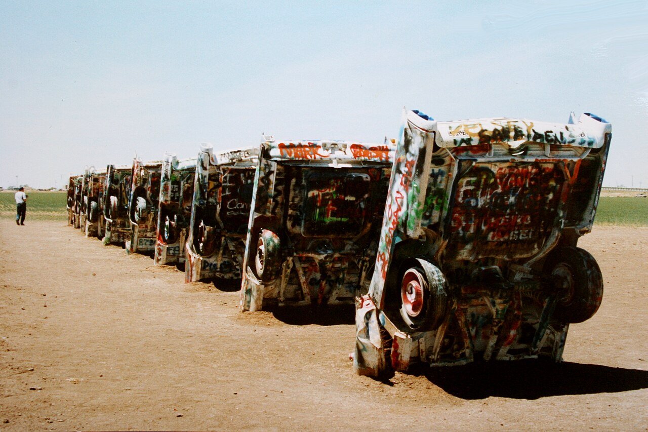 A row of graffiti-covered cars standing nose-down at Cadillac Ranch near Amarillo, Texas.